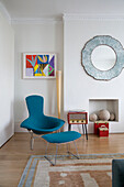 Hellblauer Sessel und Fußhocker mit modernem Kunstwerk in einem Londoner Stadthaus, England, UK
