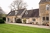 Lawn and driveway in front of terraced stone Gloucestershire cottages England UK