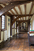 Rocking horse in wide beamed hallway of timber-framed Hampshire farmhouse England UK