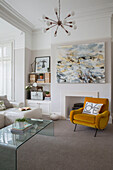 Gelber Samtsessel mit moderner Kunst und Vintage-Leuchte im Wohnzimmer in Brighouse, West Yorkshire UK