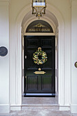 Christmas wreath on black front door of country house Kent England UK