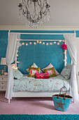 Festoon lights above child's four poster bed in Kent country house England UK
