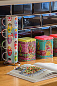Colourful cups and storage tins with recipe book in Kidderminster kitchen Worcestershire England UK