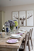 Triptych of deers head with hydrangea on dining table in London townhouse UK