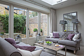 Two seater sofas under skylight in conservatory extension in London townhouse UK