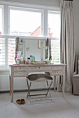 Dressing table and stool in window of London townhouse UK