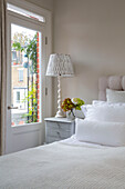 Lamp on bedside table at bedroom door in London townhouse UK