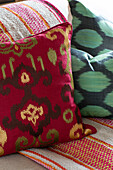 Red and green patterned cushions on sofa in Dorset farmhouse UK