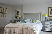Double bed with pair of lamps and botanical prints in Dorset farmhouse UK