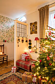 Christmas presents with tree behind door partition at entrance to Liverpool cottage UK