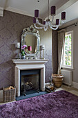 Spiegel über dem Kamin mit violettem Teppich in einem freistehenden Landhaus in Sussex UK