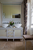 Double basins and mirror on wash stand unit in detached Sussex country house UK
