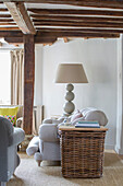 Korb und Lampe mit grauem Sofa in einem umgebauten Bauernhaus in Kent UK