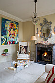 Large modern artwork in living room with lit fire and perspex table in London townhouse UK