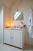 Bathrobe hangs next to wash stand with mirror in London townhouse UK