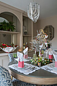 Metallic lampshade above table set for Christmas dinner in London townhouse UK