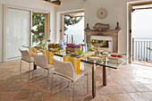 Gelbe Tischdecken auf einem gläsernen Esstisch mit Blick auf das Meer in einer Villa an der Küste von Amalfi, Italien