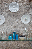 Dekorative Teller über einem Glasregal im Esszimmer einer Küstenvilla in Amalfi, Italien
