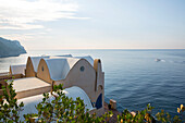 Dächer einer italienischen Villa mit Schnellboot auf dem Meer an der Amalfiküste