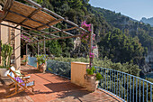 Liegestühle auf der schattigen Balkonterrasse einer italienischen Villa an der Amalfiküste