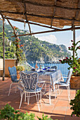 Table and chairs under shaded awning on balcony terrace of Italian villa on the Amalfi coast