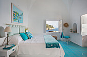 Doppelbett in einer italienischen Villa mit türkisfarbenen Bodenfliesen und Möbeln an der Amalfiküste