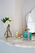 Cut flowers with perfume and necklaces on dressing table in Italian villa on the Amalfi coast