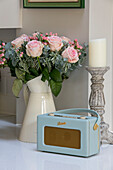 Light blue vintage radio with pink roses and candlestick in London kitchen UK