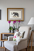 Artwork of elephant with armchair and tripod lamp in London home UK