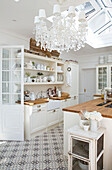Chandelier below skylight in white fitted kitchen Edwardian house Surrey UK