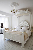 White canopy bed with cream blanket in Edwardian house Surrey UK