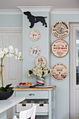 Dog ornament and decorative plates in light blue kitchen of Victorian terrace house South London UK
