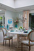 Striped dining chairs at table with candlestick in Victorian terraced house South London UK