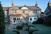 Topiary in garden of 1820s West Sussex farmhouse UK