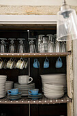 Glasses and plates with teacups on shelves in 19th century Provencal farmhouse France