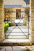 Black wrought iron gate at entrance to Gloucestershire barn conversion UK