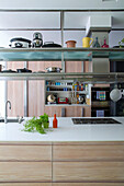 Kitchenware storage above island unit with hob in Victorian London townhouse UK