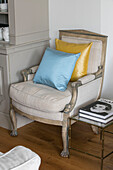 Blue and yellow cushions on cream armchair in Grade II listed villa Arundel West Sussex UK