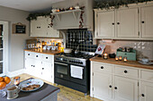 Weihnachtsgirlanden über Schränken in einer Küche in Hampshire