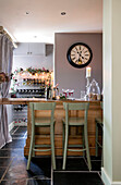 Wine rack with clock and bar stools in Hampshire home
