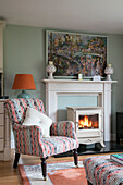 Upholstered armchair and lit woodburning stove in Wiltshire living room