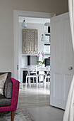 View through doorway to white dining table and chairs in modern Victorian terrace London UK