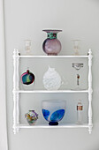 Vintage glassware on wall-mounted shelving in Victorian terraced home London UK