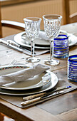 Place setting with napkin and cut wine glasses in West Sussex home UK