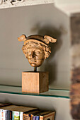 Carved head of Mercury on glass shelf in Somerset home UK
