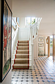 Teppichtreppe und Fliesenboden mit Kunstwerken im Flur eines Hauses in Somerset, UK