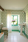 Green and white patterned wallpaper with pedestal basin in Somerset bathroom UK