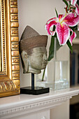 Carved Asian head and cut orchid with mirror frame in Hampshire home UK
