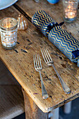 Forks and Christmas cracker on worn wooden table in Grade II listed Hampshire cottage