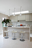 Open plan kitchen with bar stools and pendants painted Stone 1V in East Dulwich London UK